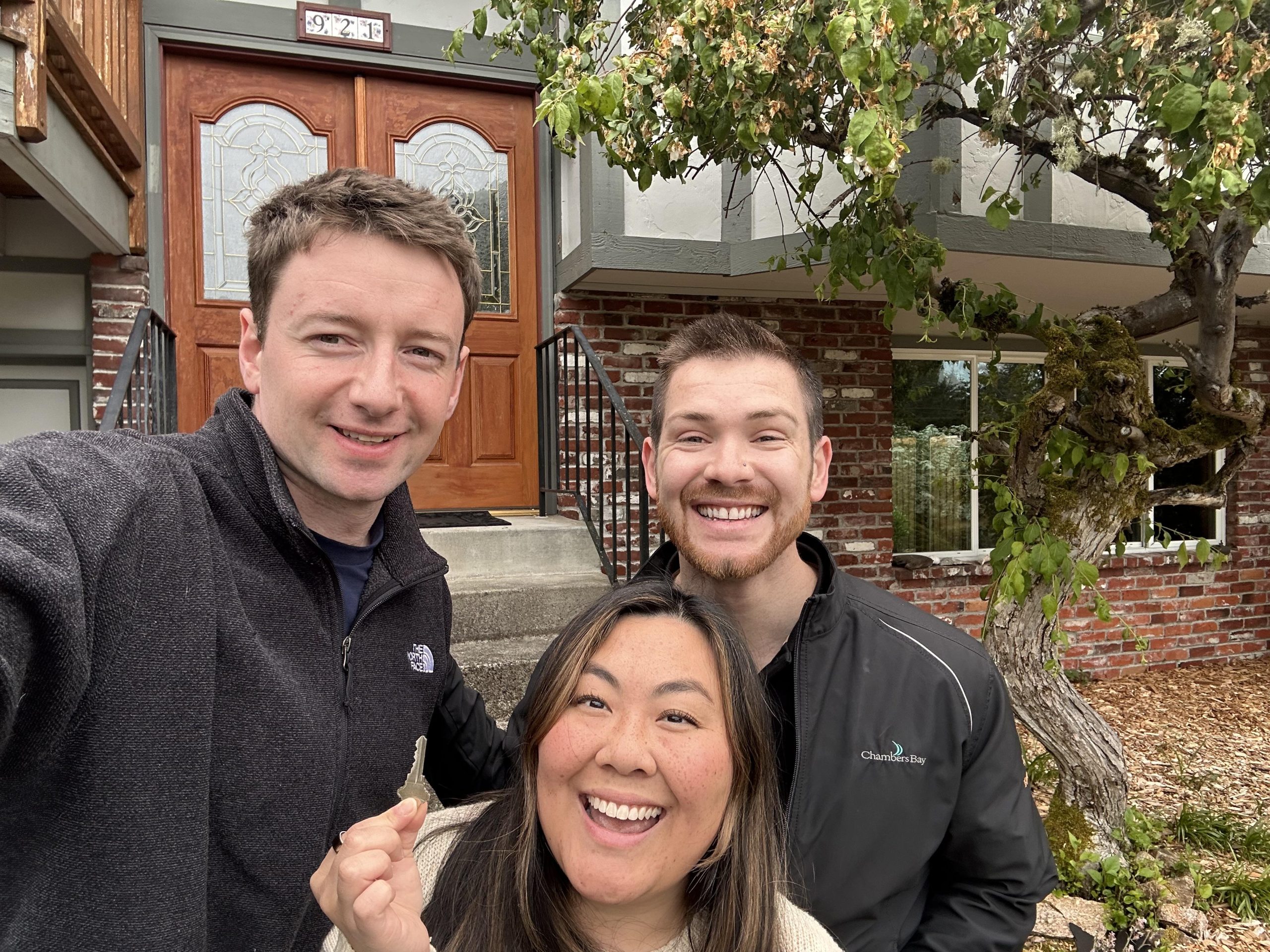 Happy clients holding keys at their new Tacoma home with Spencer Eiseman